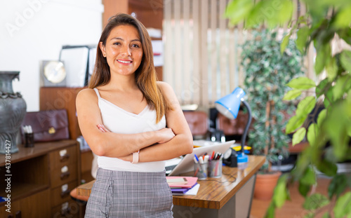 Portrait of smiling confident hispanic woman employee posing in modern office interior photo