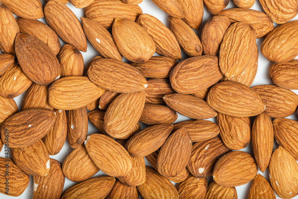 Background of big raw peeled almonds situated arbitrarily. Top view. Macro photography Background of big raw peeled almonds situated arbitrarily. Top view. Macro photography