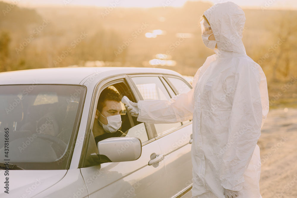 Person in a protective suit checks the temperature Person in a protective suit checks the temperature