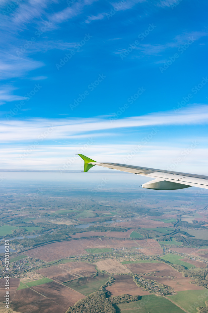 View of airplane wing, blue skies and the land during landing in Moscow, Russia. Airplane window view. View of airplane wing, blue skies and the land during landing in Moscow, Russia. Airplane window view.