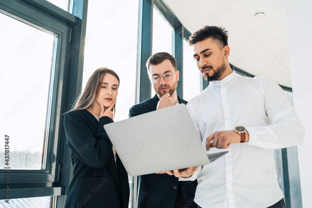Office workers show company earnings reports on laptop to their boss Office workers show company earnings reports on laptop to their boss
