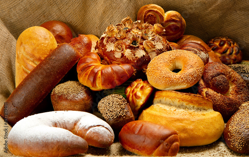 Still life of bakery products on a background of fabric. Various types of fresh bread and rolls. 