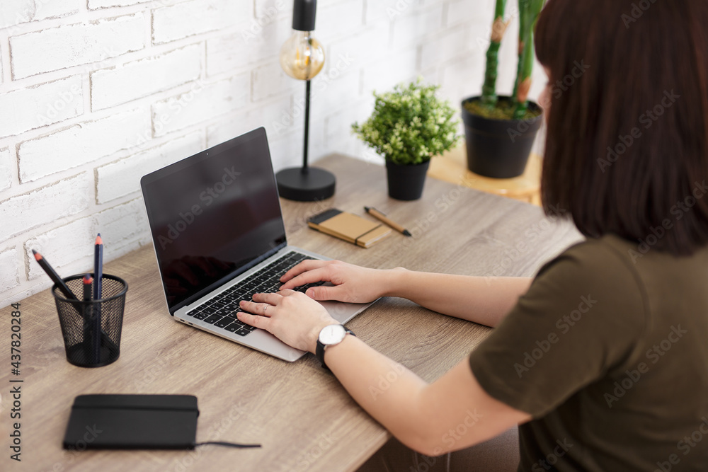 woman sitting at the table and typing on the computer woman sitting at the table and typing on the computer