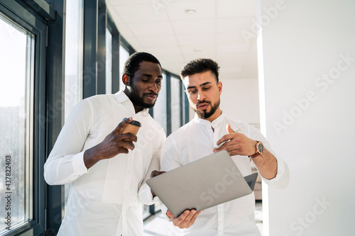 Office worker showing his boss a report on laptop