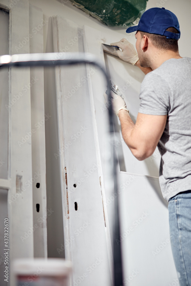 Young adult man working on a DIY budget renovation of his new home apartment. Young adult man working on a DIY budget renovation of his new home apartment.