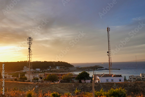 Scenic view of two cellular towers near a coast under a sunset sky photo