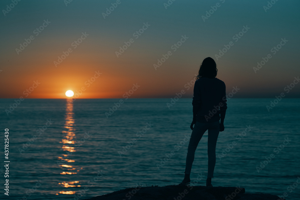 silhouette of woman on the sea at sunset and skyline beach sky
