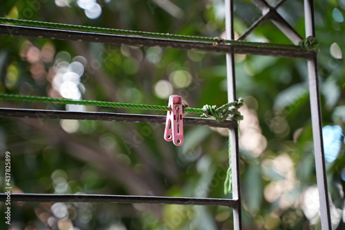 A pink cloths hanging pin on a meatal bar and in the balcony photo