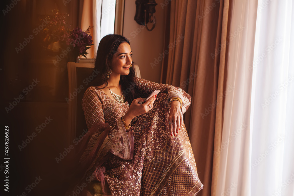 Rich beautiful Indian woman in luxury ethnic clothes using her phone in a 5  star hotel room. Filtered portrait in muted colors, film photography style  Stock Photo | Adobe Stock