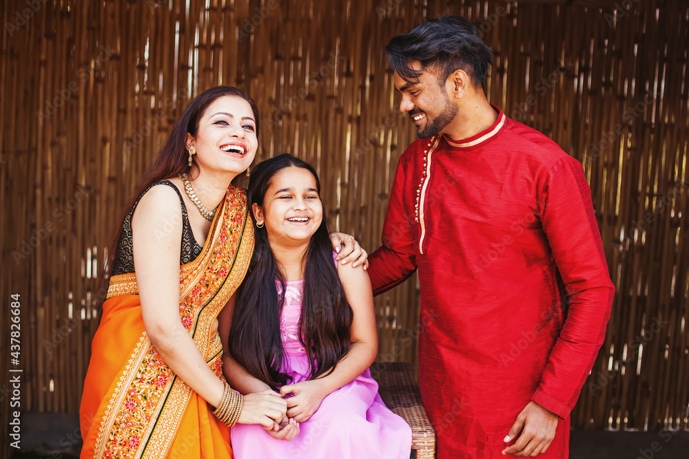 Beautiful Indian young family laughing, hugging, spending time together at home
