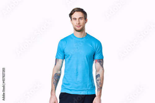 athlete with dumbbells on a light background and blue t-shirt pants tattoo © SHOTPRIME STUDIO