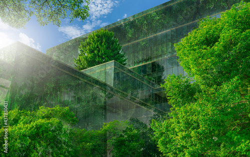 Eco-friendly building with vertical garden in modern city. Green tree forest on sustainable glass building. Energy-saving architecture with vertical garden. Office building with green environment.