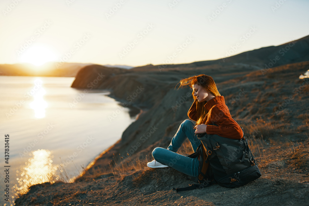 woman tourist sitting on the ground admiring nature landscape fresh air
