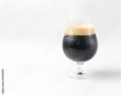 Full beer tulip glass of stout or porter isolated on white background. Beer in a glass, alcoholic beverage