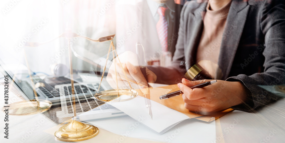 Justice and law concept.Male judge in a courtroom with the gavel, working with, computer and docking keyboard, eyeglasses, on table in morning light Justice and law concept.Male judge in a courtroom with the gavel, working with, computer and docking keyboard, eyeglasses, on table in morning light