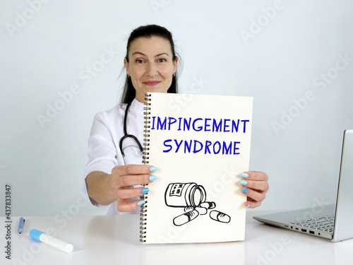  IMPINGEMENT SYNDROME phrase on the screen. Podiatrist use cell technologies at office. photo