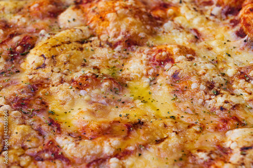 Close-up of pizza topped with cheese and oregano. Macro shot of delicious products. Selective focus.