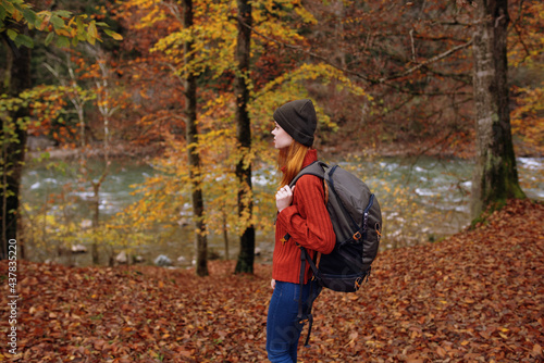 side view of happy woman in park in autumn near river and backpack on her back © SHOTPRIME STUDIO