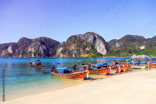 Travel photo of amazing Koh Phi Phi in Thailand. Deep plus clear water, mountains and local boats in hot tropical exotic island.