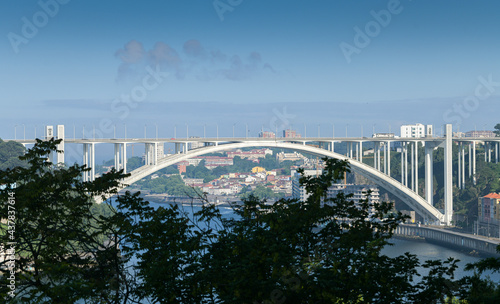Ponte da Arrábida landmark bridge in Porto city from Portugal during a beautiful summer day with blue sky. © Dragoș Asaftei