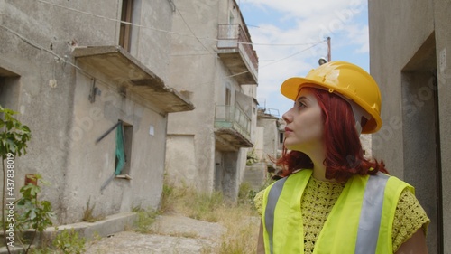 Giovane donna tecnico o ingegnere controlla la città distrutta dopo il terremoto photo