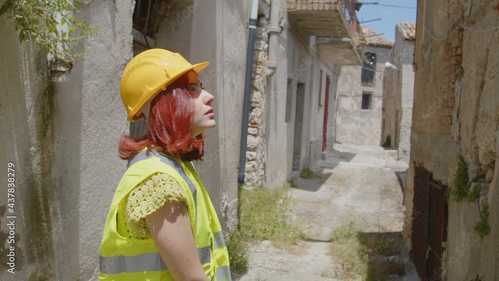 Giovane donna tecnico o ingegnere controlla la città distrutta dopo il terremoto