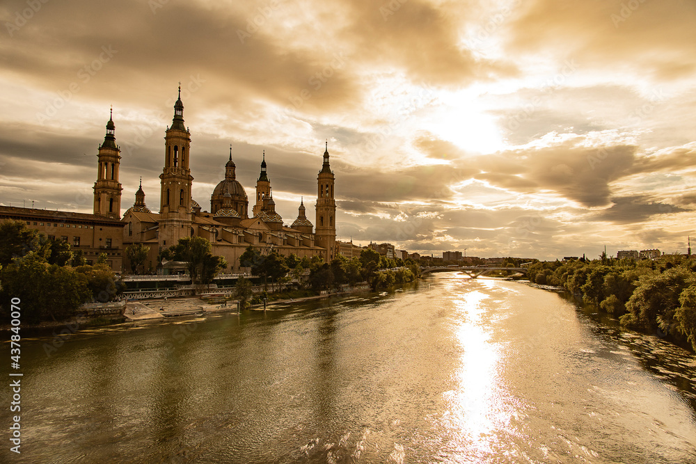  landscape from the Spanish city of Saragossa with the basilica and the Ebro river in the background of the sun setting in the sky