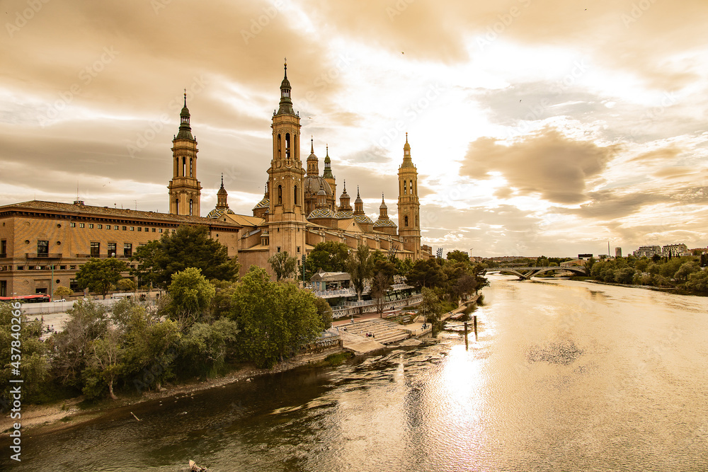  landscape from the Spanish city of Saragossa with the basilica and the Ebro river in the background of the sun setting in the sky