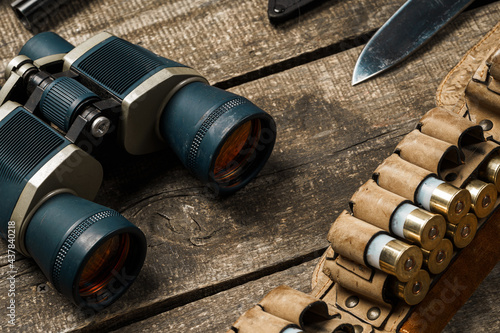 Hunting equipment binoculars on wooden background close up