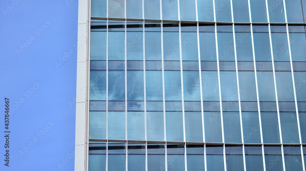 Modern architecture with sun ray. Glass and steel facade on a bright sunny day with sunbeams on the blue sky. Economy, finances, business activity concept. Modern architecture with sun ray. Glass and steel facade on a bright sunny day with sunbeams on the blue sky. Economy, finances, business activity concept.