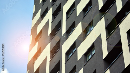 Modern apartment buildings on a sunny day with a blue sky. Facade of a modern apartment building. Glass surface with sunlight.