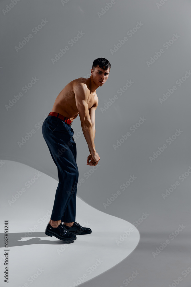 beautiful couple with pumped up muscles of the arms in jeans and patent leather shoes bent down in full growth beautiful couple with pumped up muscles of the arms in jeans and patent leather shoes bent down in full growth
