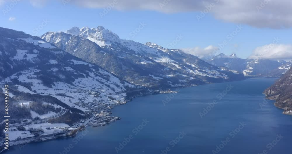 Wide aerial drone shot between the high Alps of Switserland which are covered with white snow on a partly cloudy day. Wide aerial drone shot between the high Alps of Switserland which are covered with white snow on a partly cloudy day.
