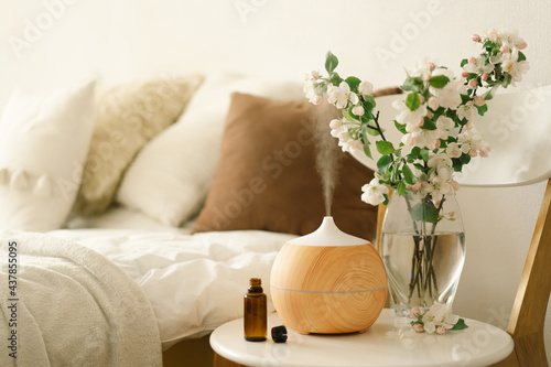 Aromatherapy Concept. Aroma oil diffuser on chair against in the bedroom. Air freshener. photo