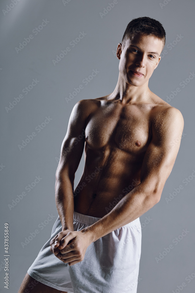 athlete with pumped up arm muscles press bodybuilder portrait cropped view gray background