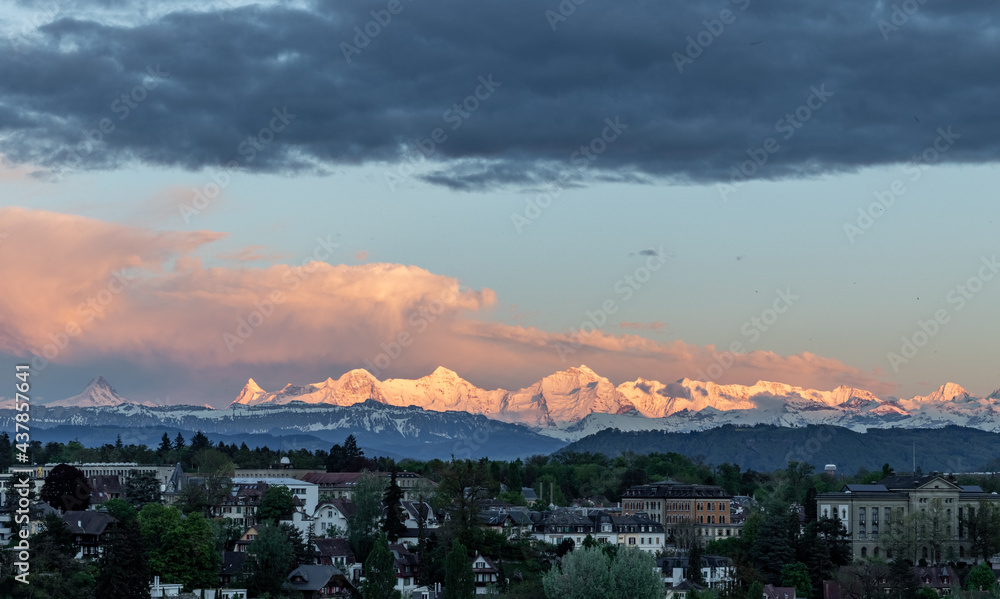 Sunset light on mountain range eiger moench and jungfrau above bern suburbs