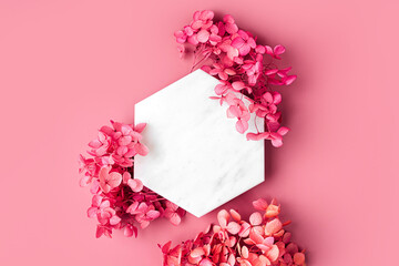 Marble  hexagon on pink background with flowers. Stylish background for presentation.