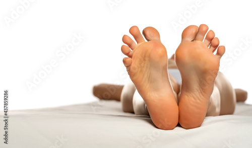 female soles on a white bed photo