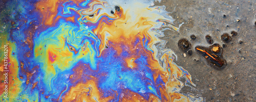 Foto puddle gasoline background, wet oil multicolored rainbow pollution spill
