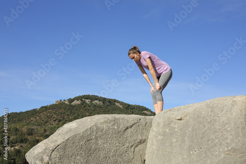Exhausted runner resting in the top of a cliff
