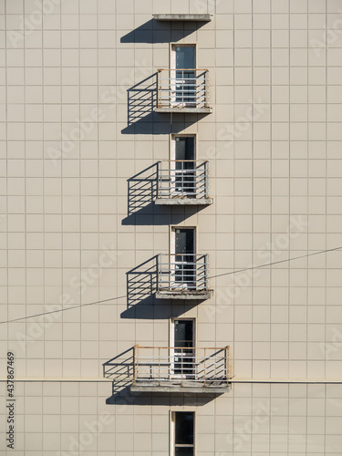 The wall of the facade of a multi-storey building with balconies. The shadow from the balconies in a multi-storey building creates an additional reality. Unusual texture. Wallpaper and background.