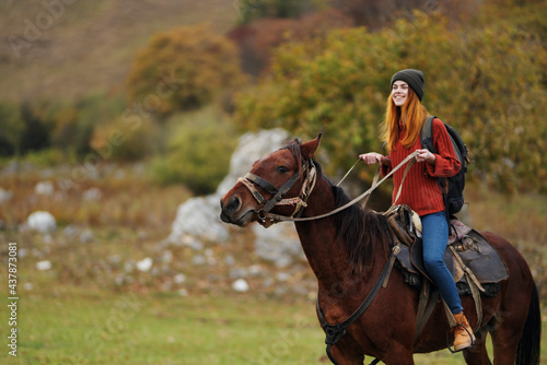 woman hiker riding a horse on nature mountains adventure