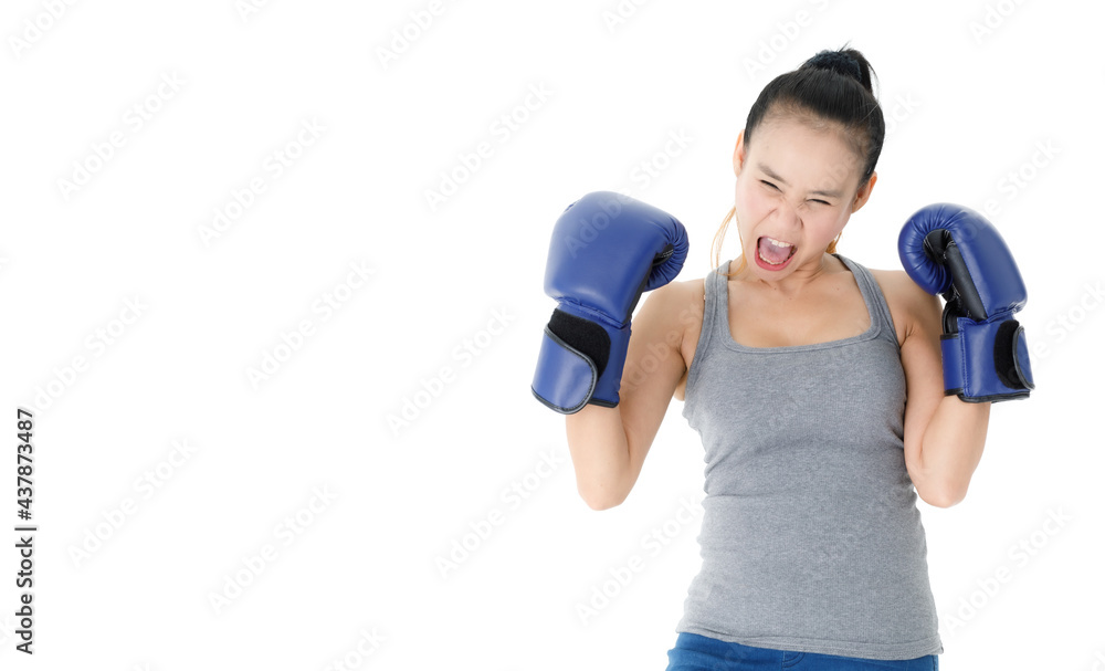 Confident woman in boxing gloves punching in studio Confident woman in boxing gloves punching in studio
