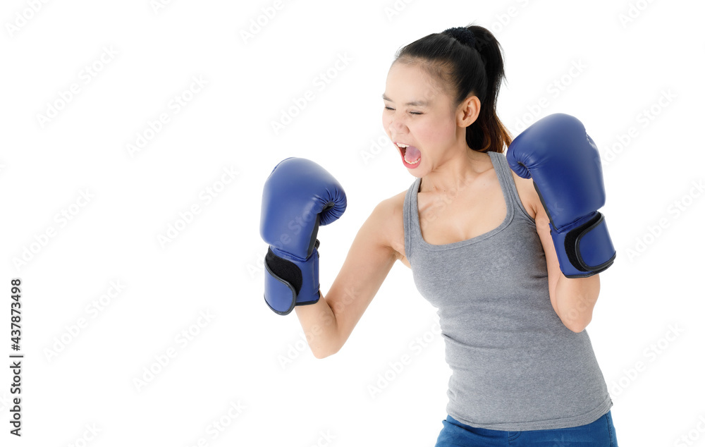 Confident woman in boxing gloves punching in studio Confident woman in boxing gloves punching in studio