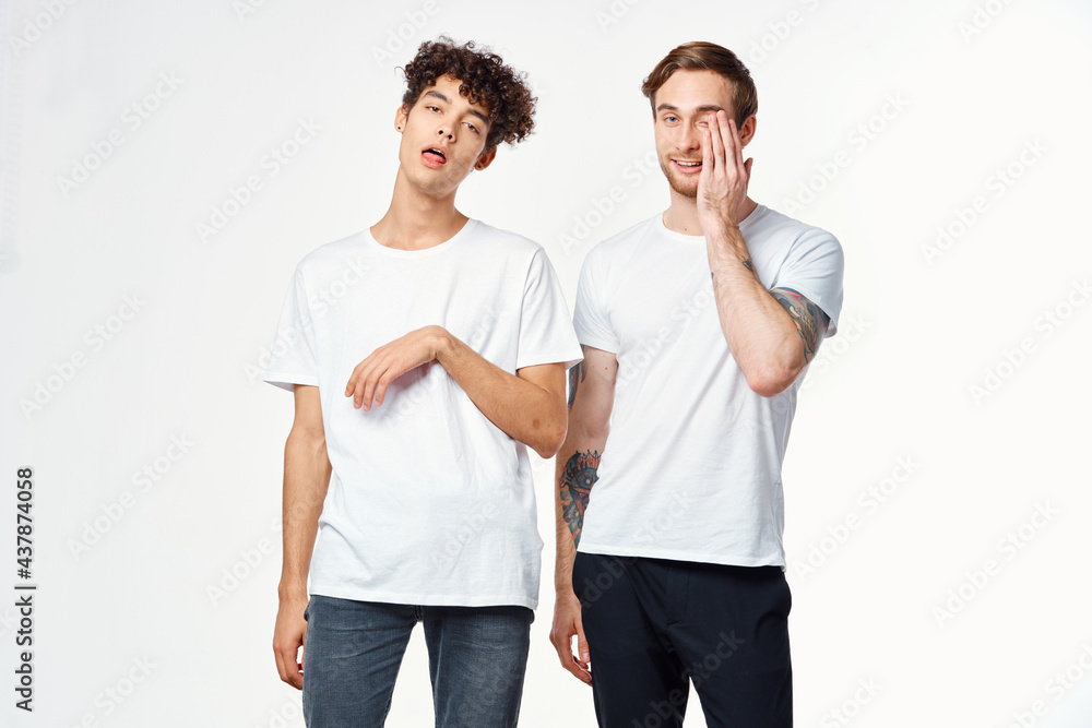 Two cheerful friends in white t-shirts emotions positive light background Two cheerful friends in white t-shirts emotions positive light background