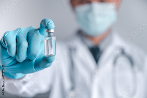 Doctors wear a surgical mask and glasses, Scientists hold syringes and vaccines for COVID-19. vaccination and laboratory experiments. Virus protection concept COVID-19.