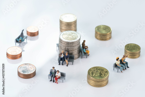 Euro coins and miniature people sitting on benches