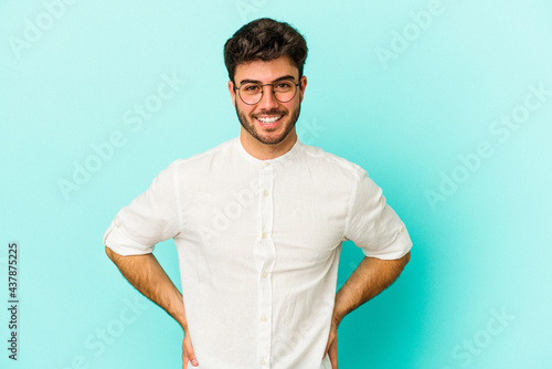 Young caucasian man isolated on blue background happy, smiling and cheerful. © Asier