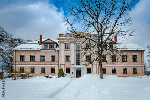 Path leads through the snowy park to the manor. Cere Manor, Latvia. The Cēre primary school is located in the manor house.
