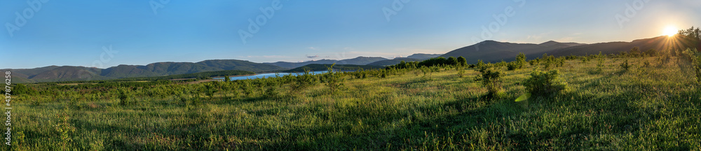 Beautiful green hills and valley in setting sun light. Beautiful summer landscape panorama. Nature background. Copy space.
